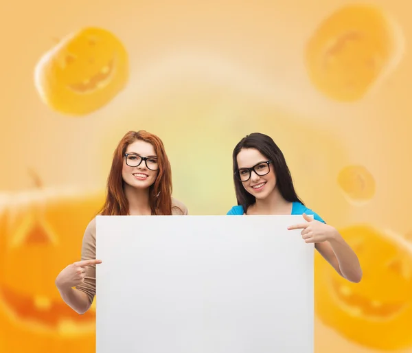 Smiling teenage girls with white board — Stock Photo, Image