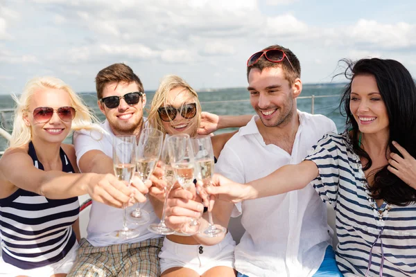 Amigos sonrientes con copas de champán en el yate —  Fotos de Stock