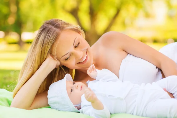 Glückliche Mutter liegt mit kleinem Baby auf Decke — Stockfoto