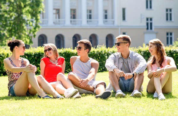 Groupe d'amis souriants à l'extérieur assis sur l'herbe — Photo