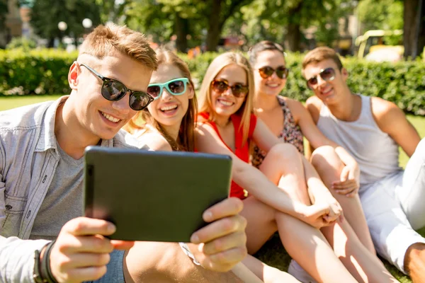 Lachende vrienden met de tablet pc maken selfie — Stockfoto