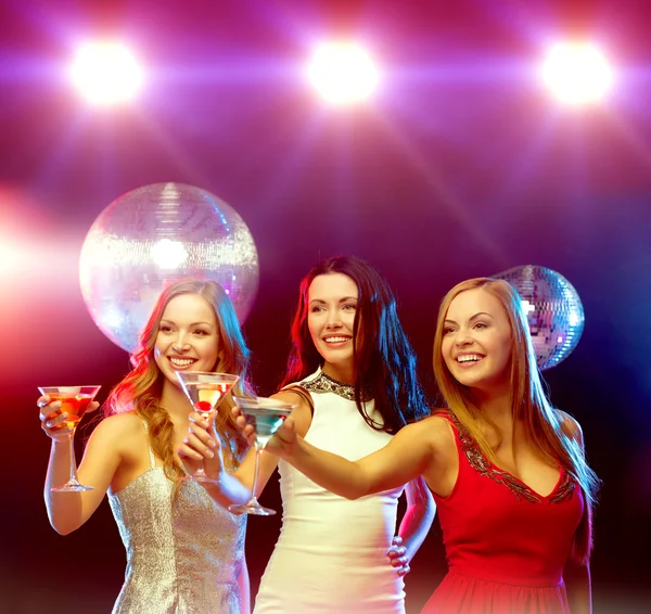 Tres mujeres sonrientes con cócteles y bola disco — Foto de Stock