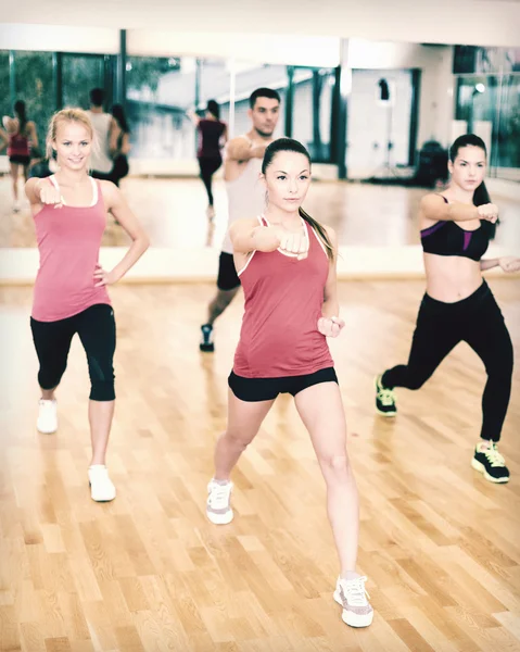 Grupo de personas concentradas haciendo ejercicio en el gimnasio — Foto de Stock