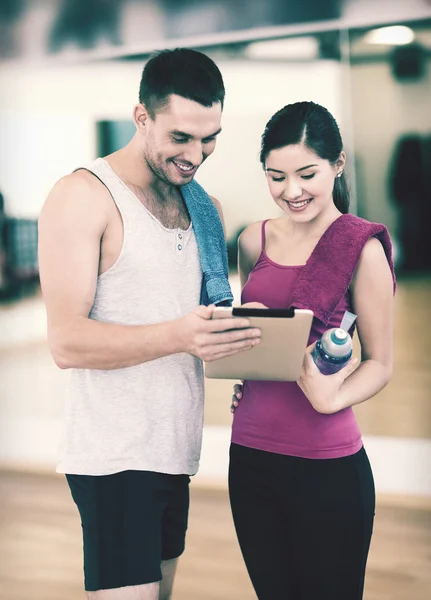 Deux personnes souriantes avec tablette PC dans la salle de gym — Photo