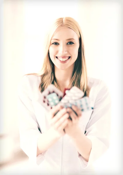 Jonge vrouwelijke arts met pack van pillen — Stockfoto