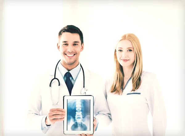 Two doctors showing x-ray on tablet pc — Stock Photo, Image