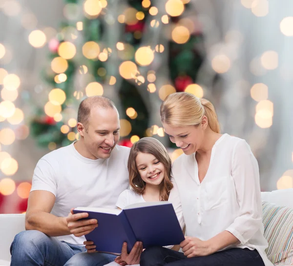 Gelukkige familie met boek thuis — Stockfoto