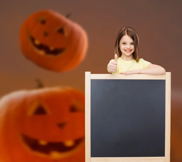 Smiling little girl with blackboard — Stock Photo, Image