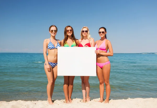 Gruppo di donne sorridenti con tavola bianca sulla spiaggia — Foto Stock