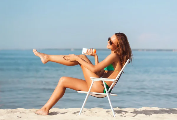 Lächelnde junge Frau sonnt sich in Lounge am Strand — Stockfoto