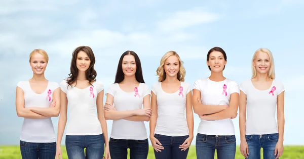 Улыбающиеся женщины с розовыми лентами для информирования о раке — стоковое фото