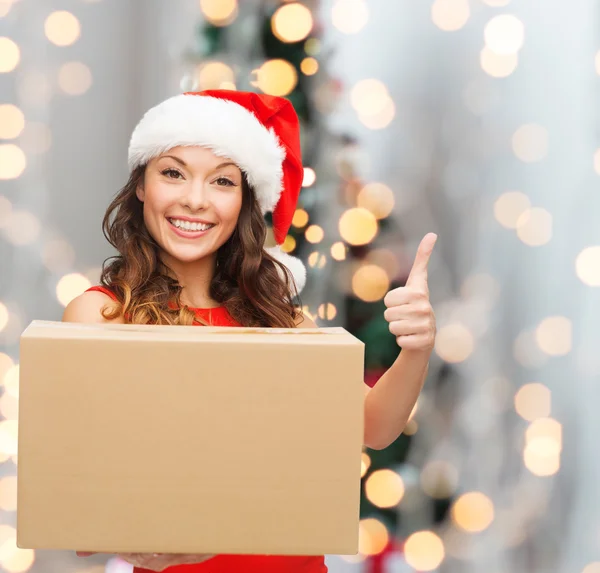 Mujer sonriente en sombrero de ayudante de santa con caja de paquete —  Fotos de Stock