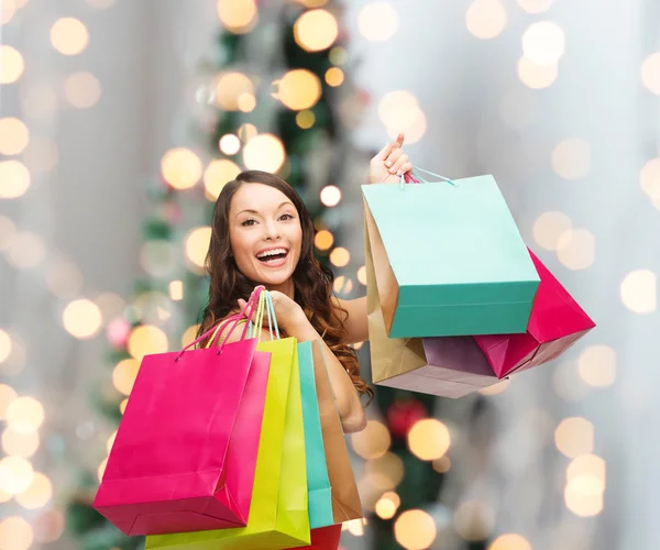 Mulher sorridente com sacos de compras coloridos — Fotografia de Stock