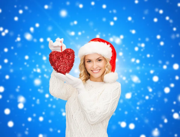 Lächelnde Frau mit Weihnachtsmann-Helfermütze mit rotem Herz — Stockfoto