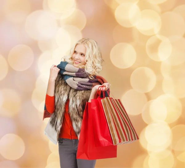 Sorrindo jovem mulher com sacos de compras vermelhos — Fotografia de Stock