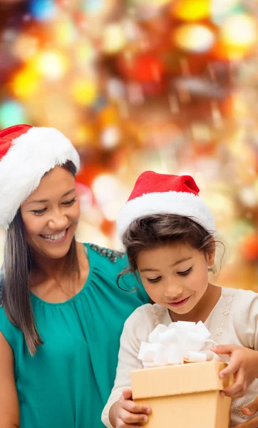 Glückliche Mutter und Mädchen in Weihnachtsmützen mit Geschenkbox — Stockfoto