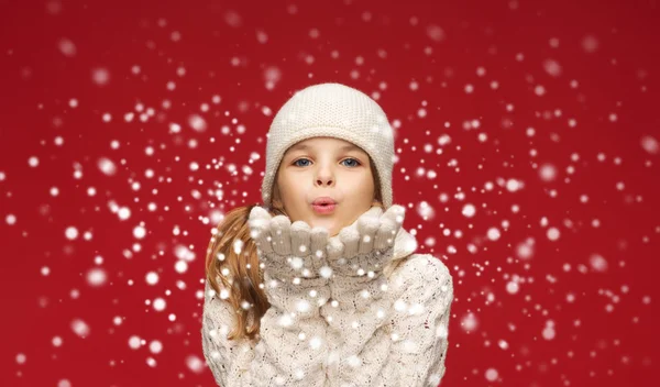 Menina feliz em roupas de inverno soprando nas palmas das mãos — Fotografia de Stock