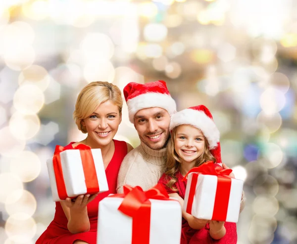 Família feliz em santa helper chapéus com caixas de presente — Fotografia de Stock