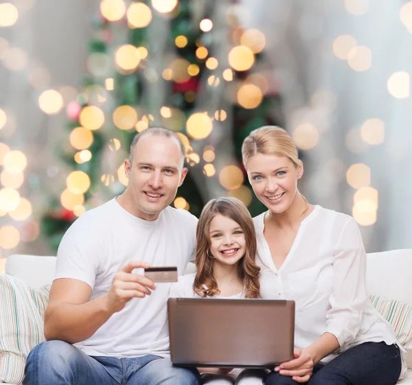Lycklig familj med bärbar dator och kreditkort — Stockfoto