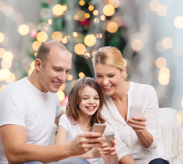 Счастливая семья со смартфонами — стоковое фото