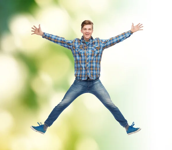 Lachende jonge man springen in de lucht — Stockfoto