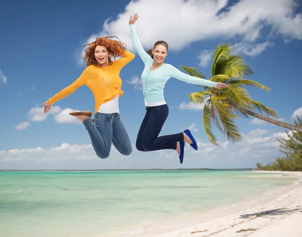 Uśmiechnięte młode kobiety skoki w powietrzu — Zdjęcie stockowe