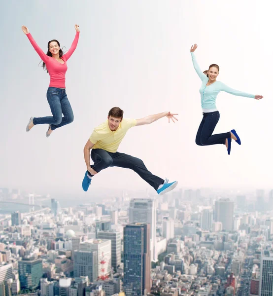 Group of smiling teenagers jumping in air — Stock Photo, Image