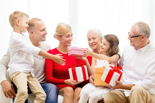 Famiglia sorridente con regali a casa — Foto Stock