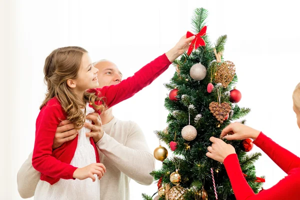 Lächelnde Familie schmückt Weihnachtsbaum zu Hause — Stockfoto