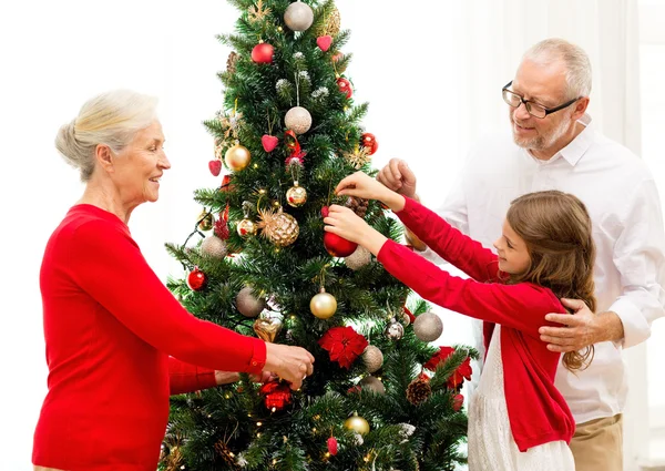 Lächelnde Familie schmückt Weihnachtsbaum zu Hause — Stockfoto