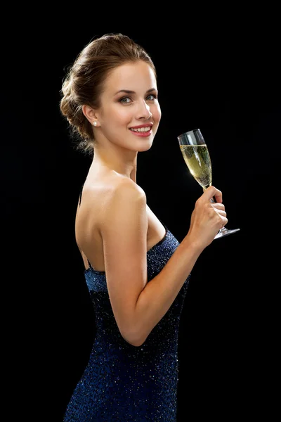 Smiling woman holding glass of sparkling wine — Stock Photo, Image