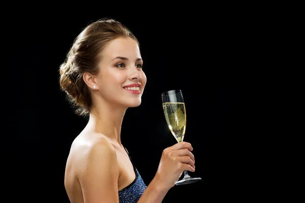 Sonriente mujer sosteniendo un vaso de vino espumoso — Foto de Stock