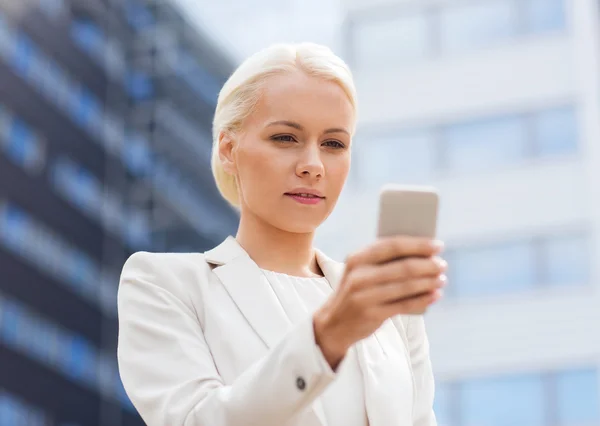 Serious businesswoman with smartphone outdoors — Stock Photo, Image