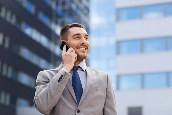 Uomo d'affari sorridente con smartphone all'aperto — Foto Stock