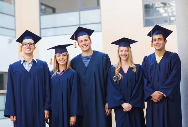 Grup gülümseyen öğrenci mortarboards içinde — Stok fotoğraf