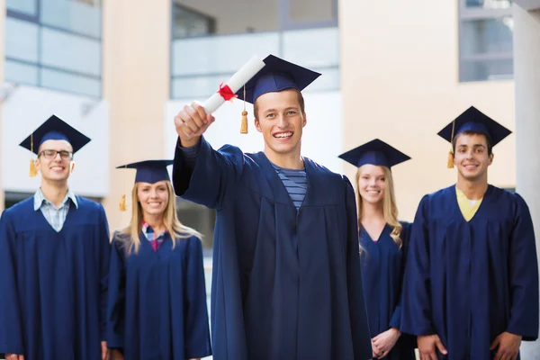 Grup gülümseyen öğrenci mortarboards içinde — Stok fotoğraf