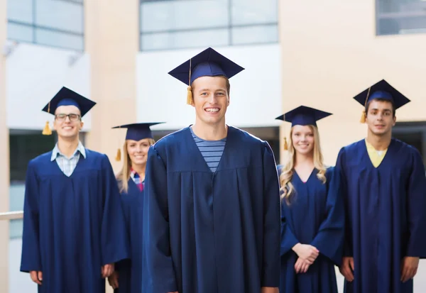 Grup gülümseyen öğrenci mortarboards içinde — Stok fotoğraf