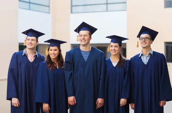 Gruppo di studenti sorridenti in mortai — Foto Stock