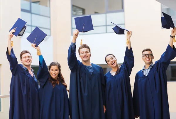 Group of smiling students in mortarboards — Stock Photo, Image