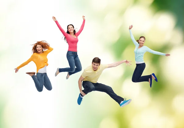 Gruppo di adolescenti sorridenti che saltano in aria Foto Stock