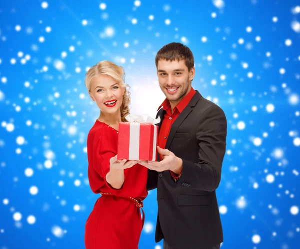 Sorridente homem e mulher com presente — Fotografia de Stock