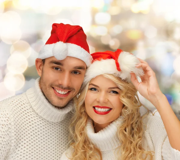 Coppia sorridente in maglioni e cappelli Babbo Natale aiutante — Foto Stock