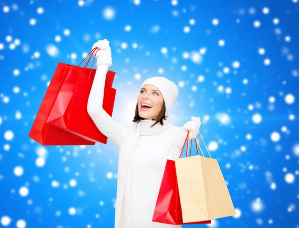 Smiling young woman with red shopping bags — Stock Photo, Image