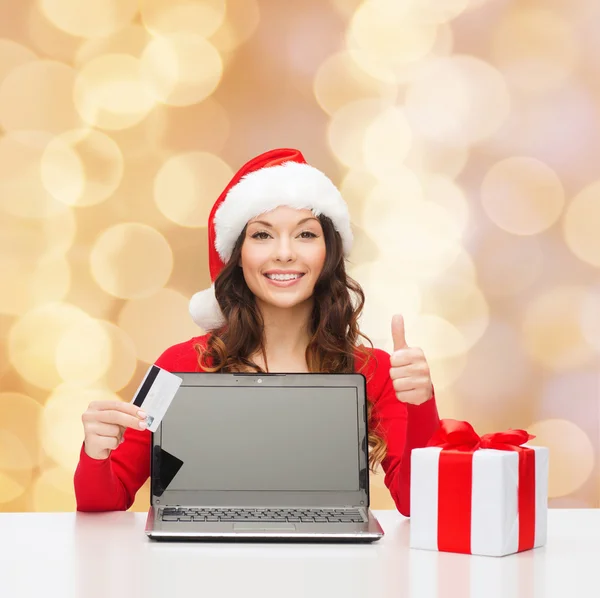 Donna sorridente con carta di credito e laptop — Foto Stock