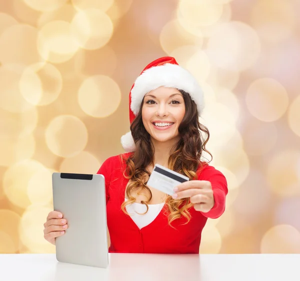 Mulher em santa hat com tablet pc e cartão de crédito — Fotografia de Stock