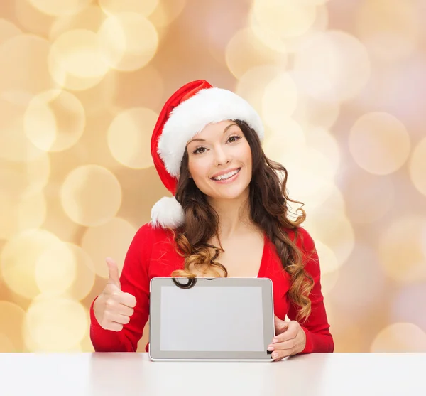 Lachende vrouw in kerstmuts met een geschenk en tablet pc — Stockfoto