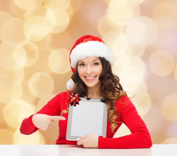 Lachende vrouw in kerstmuts met een geschenk en tablet pc — Stockfoto