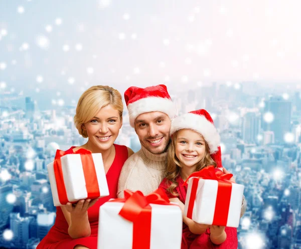 Família feliz em santa helper chapéus com caixas de presente — Fotografia de Stock