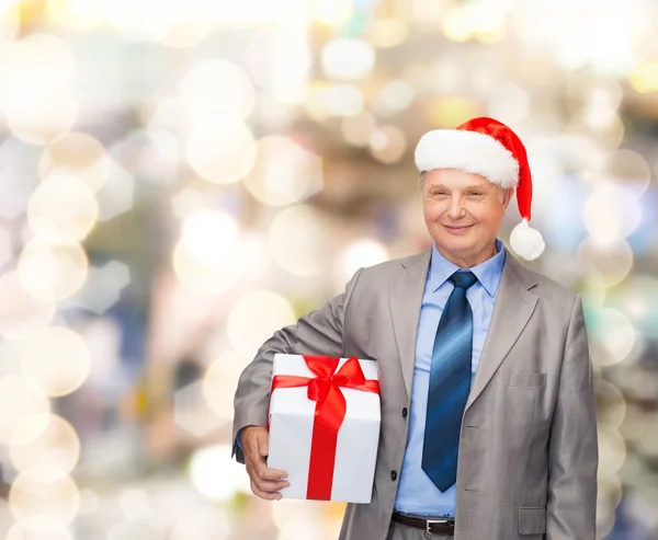 Glimlachende man in pak en santa helper hoed met cadeau — Stockfoto