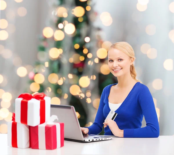 Mulher sorridente com cartão de crédito e laptop — Fotografia de Stock